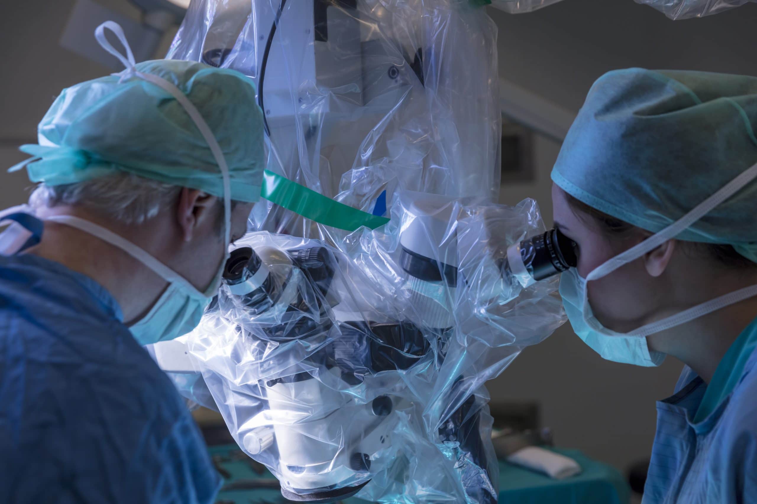 A Surgeon And Assistant Look Into An Eyepiece, Guiding The Da Vinci Surgical System To Perform A Robotic Hysterectomy