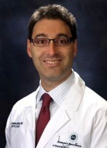 Jonathan Zaidan wearing a suit and tie smiling at the camera