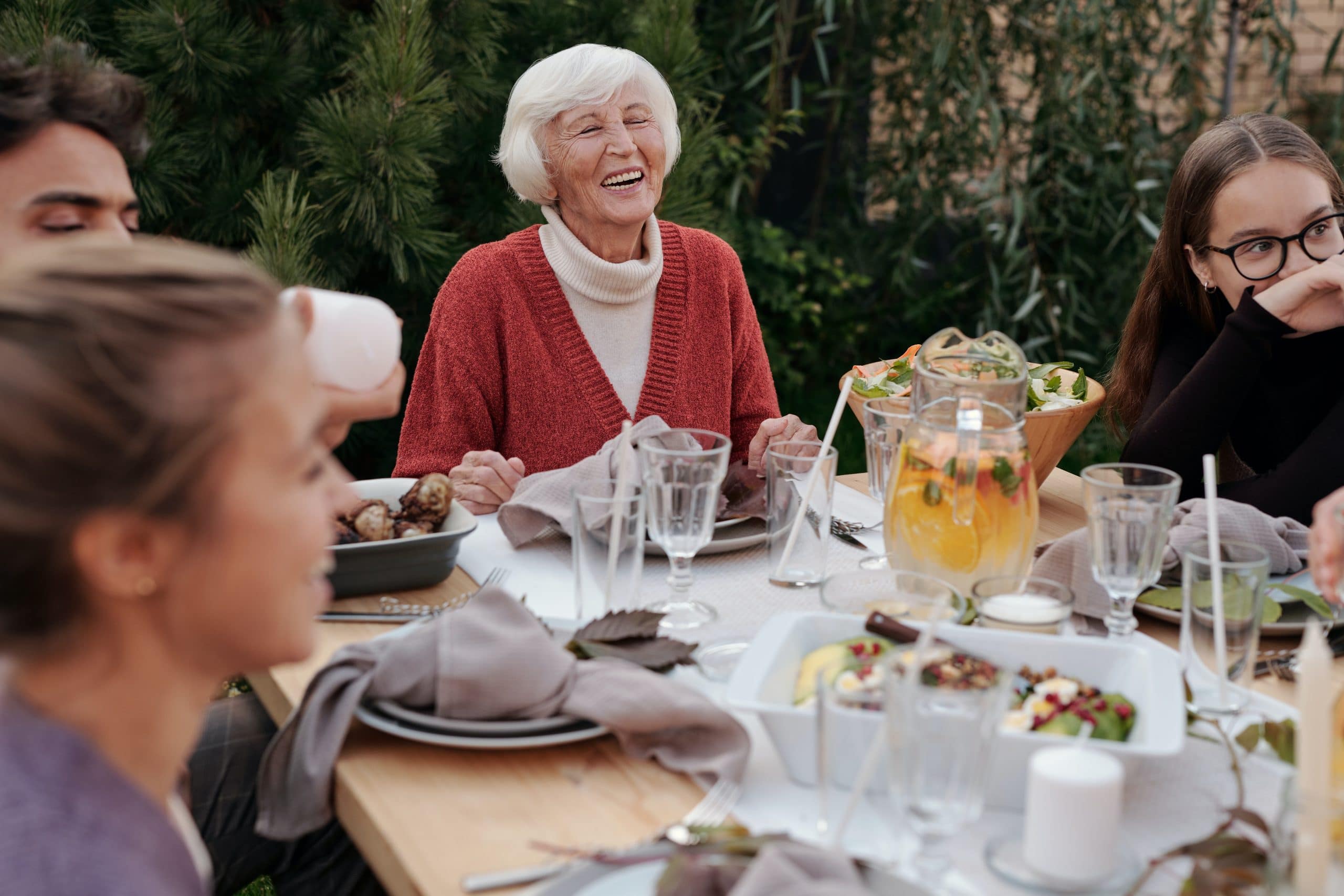 A happy older woman enjoys a family gathering worry-free thanks to cutting-edge incontinence treatment