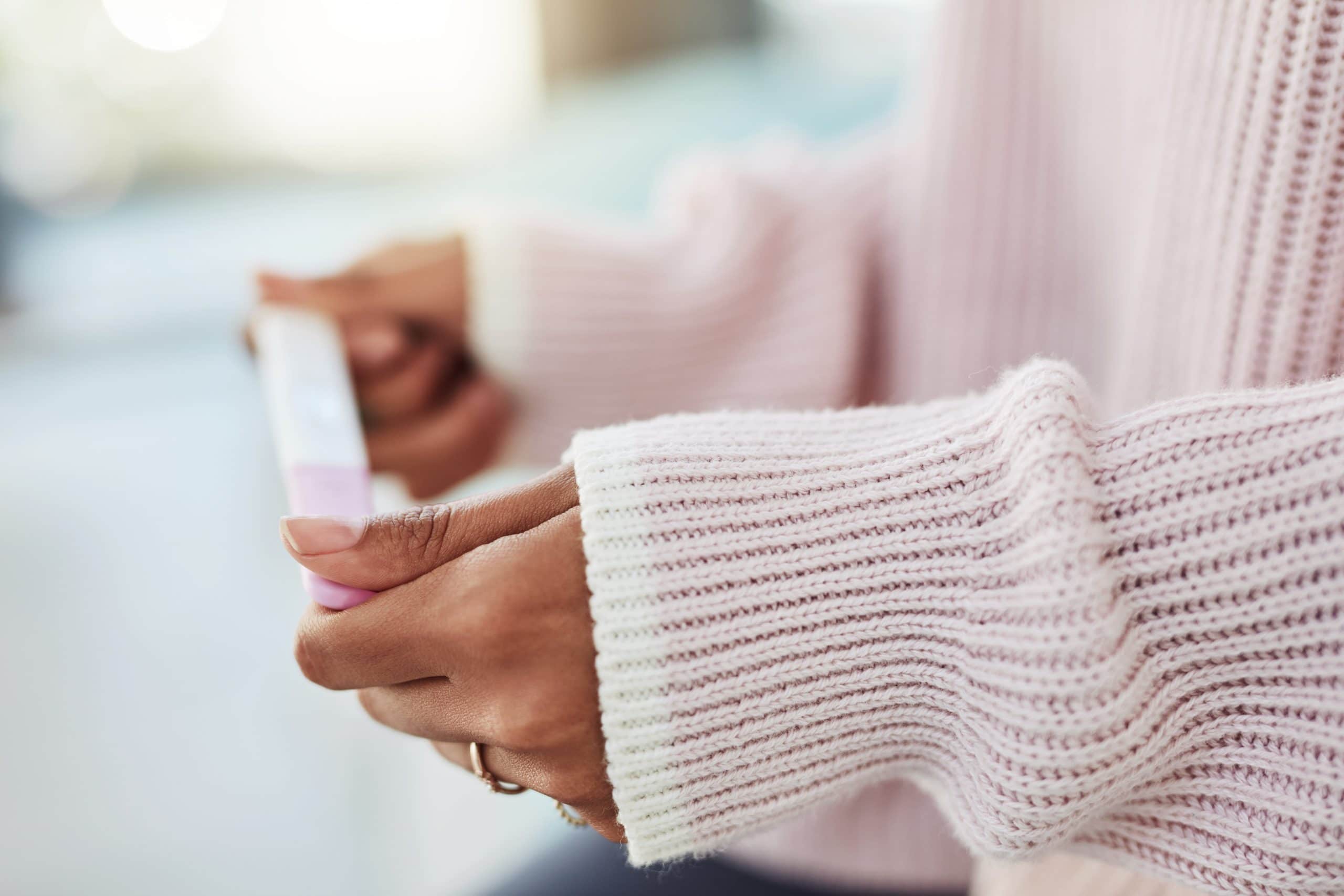 A woman holds a pregnancy test. Many women with endometriosis struggle with infertility.