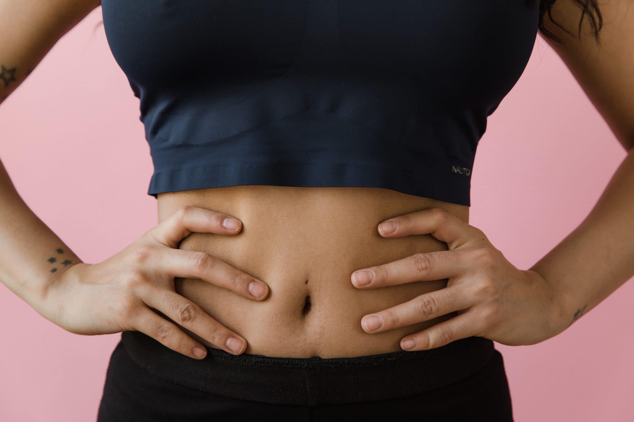 A woman wearing athletic gear with hands on her hips and renewed confidence with emsella pelvic floor strengthening